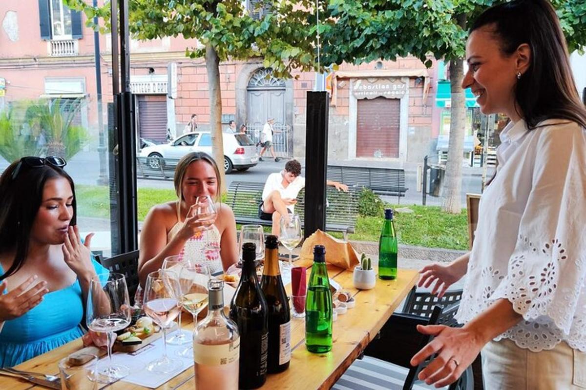 Un grupo de mujeres sentadas en una mesa con botellas de vino.