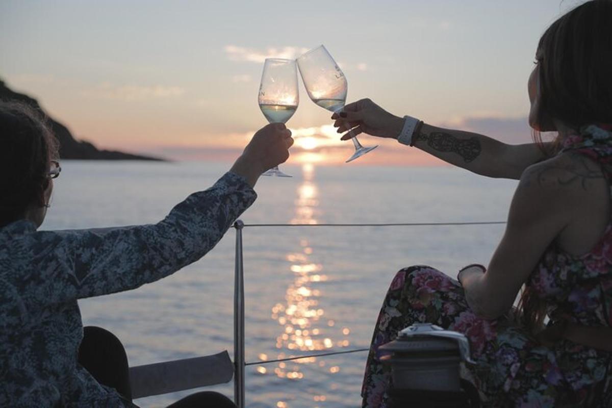 muž a žena držící sklenice na víno před oceánem