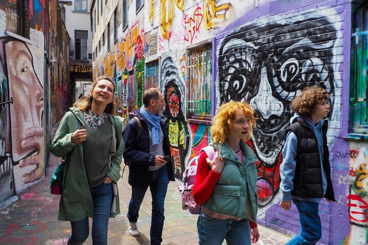 skupina lidí jdoucích před zdí s graffiti