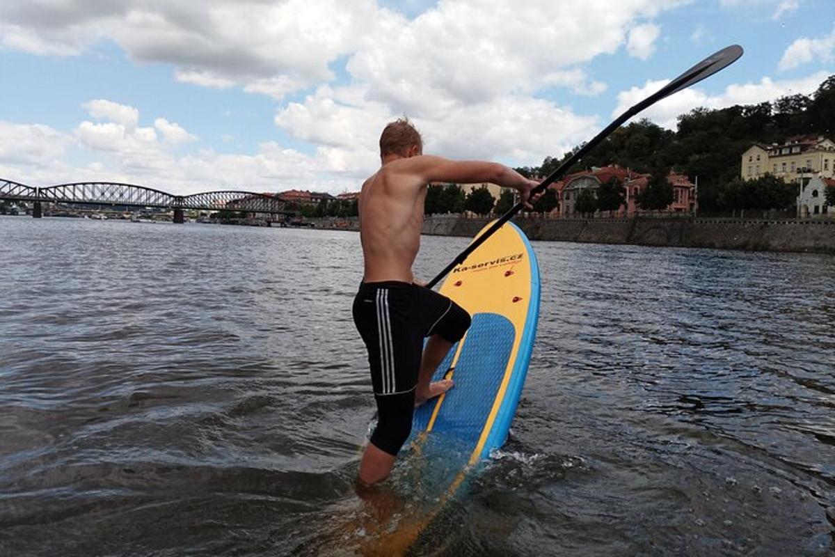 un uomo in piedi su una tavola da paddle in acqua