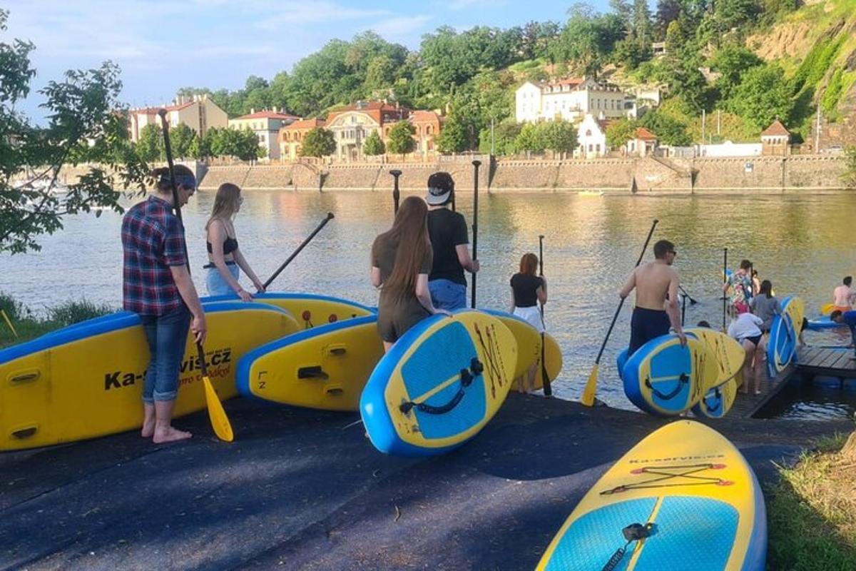 un gruppo di persone in piedi nell'acqua con i kayak