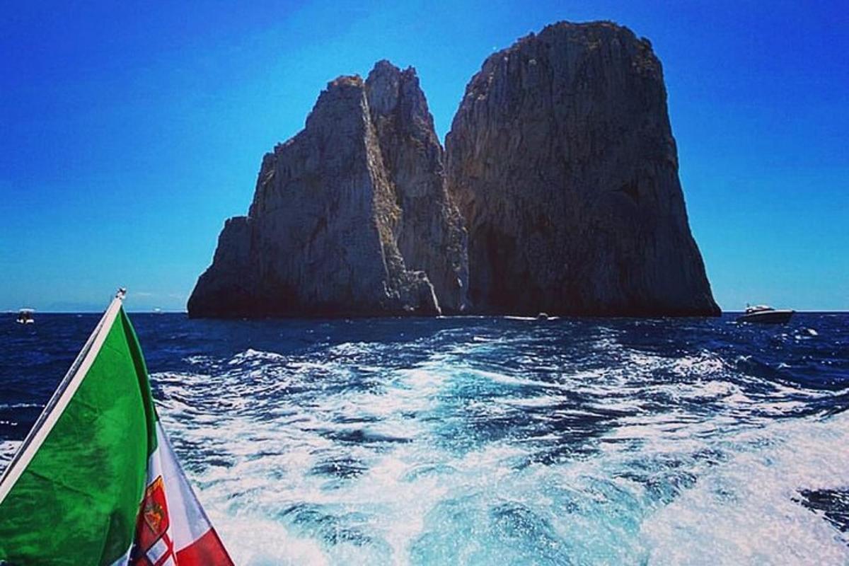 um barco no oceano com uma grande formação rochosa