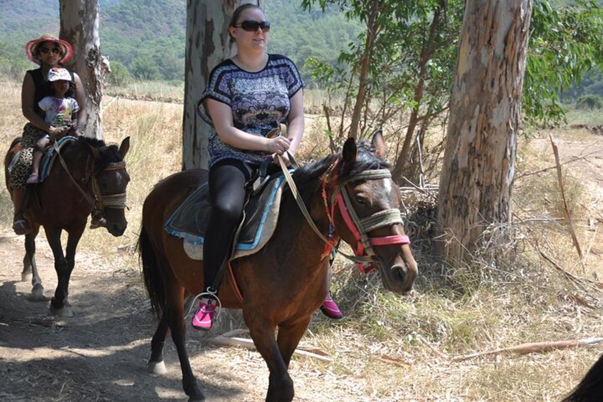 o femeie călare pe un cal cu un copil pe el