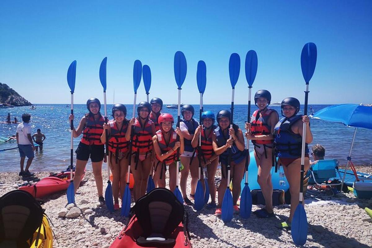 en gruppe kvinner som står på stranden med padler
