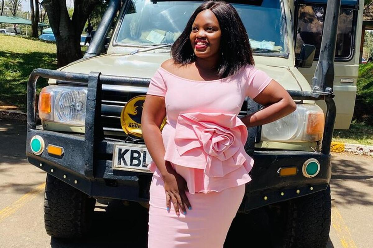 une femme en robe rose debout devant un camion
