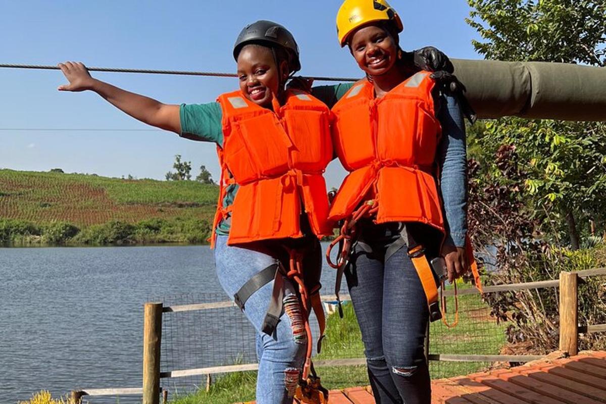 turuncu can yelekleri giymiş iki kadın zipline'da duruyor