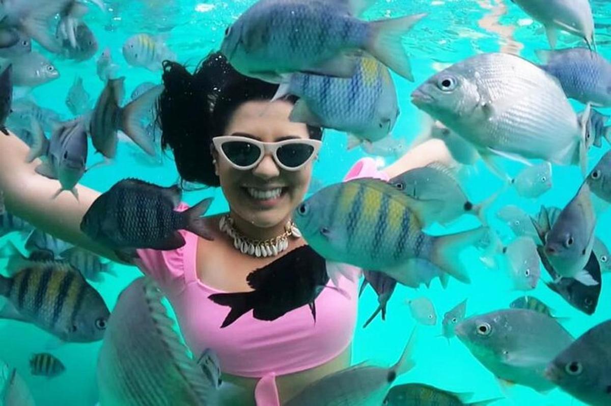 Una mujer en un tanque con un grupo de peces.