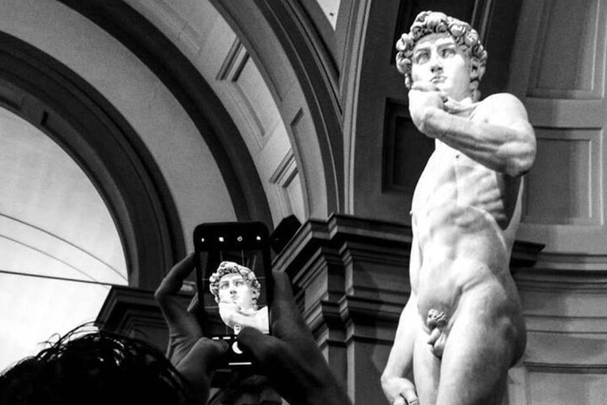 a person taking a picture of a statue in a museum