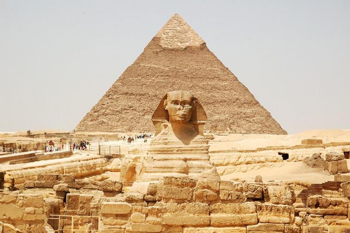 a statue in front of the pyramid