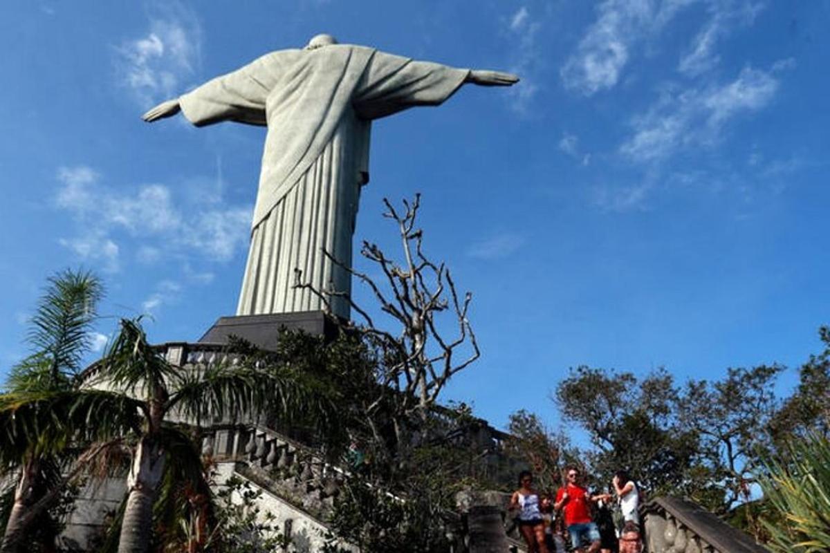 pessoas em pé em frente à estátua do Cristo Redentor