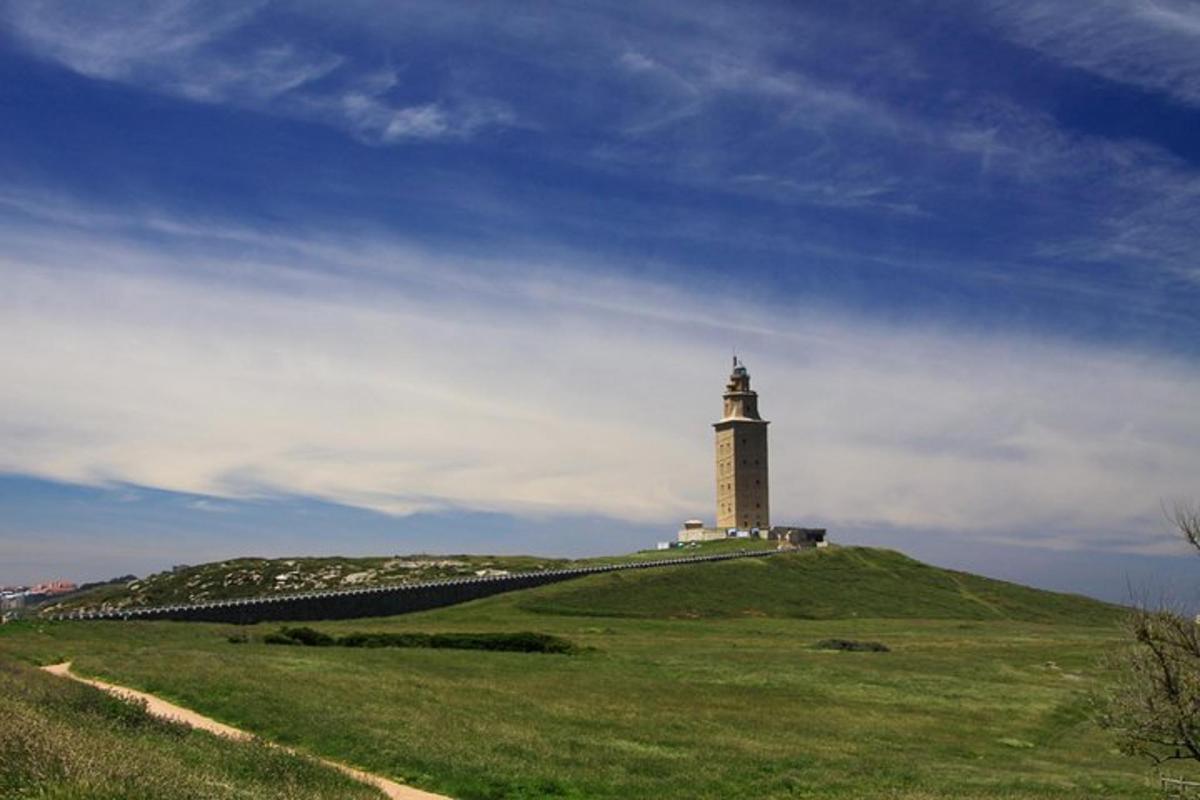 a lighthouse on top of a grassy hill