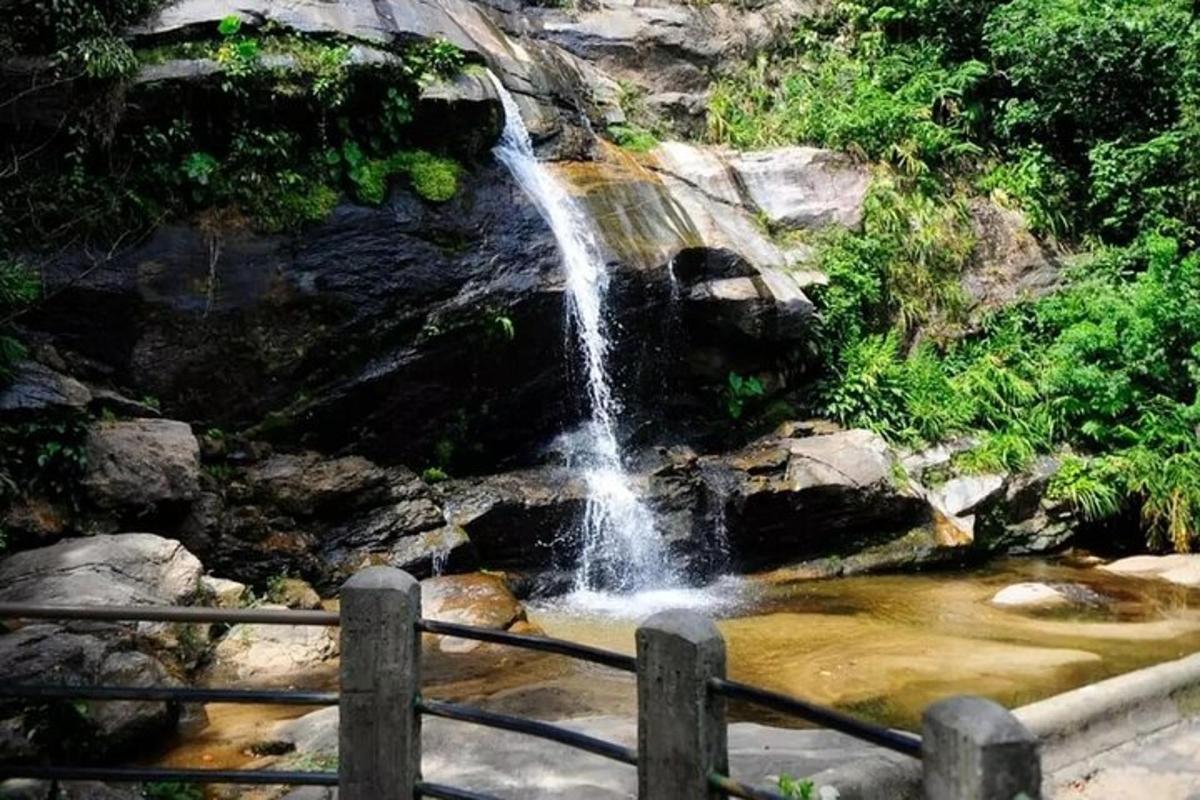 uma cachoeira em um rio com uma cerca na frente