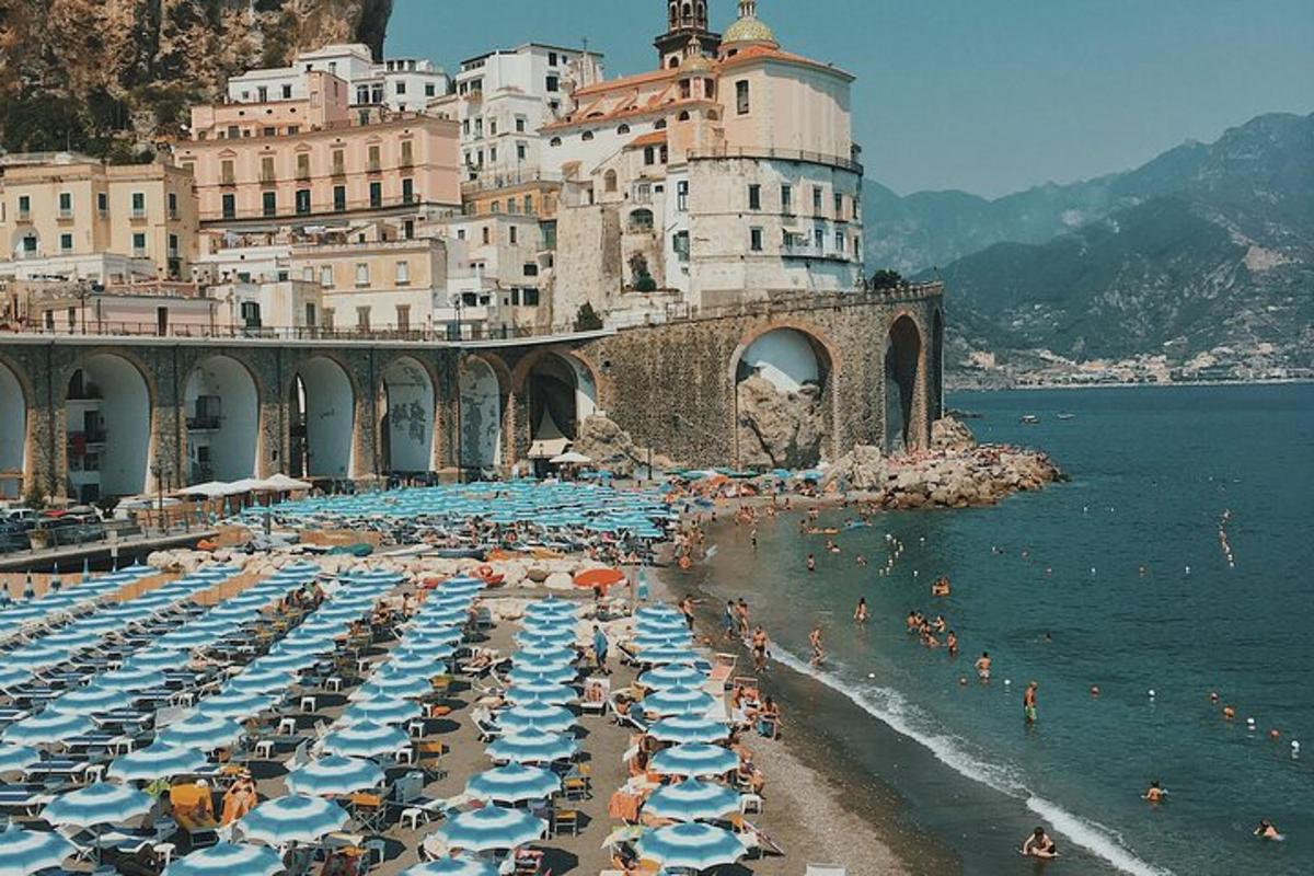 egy strand napernyőkkel és emberekkel a vízben
