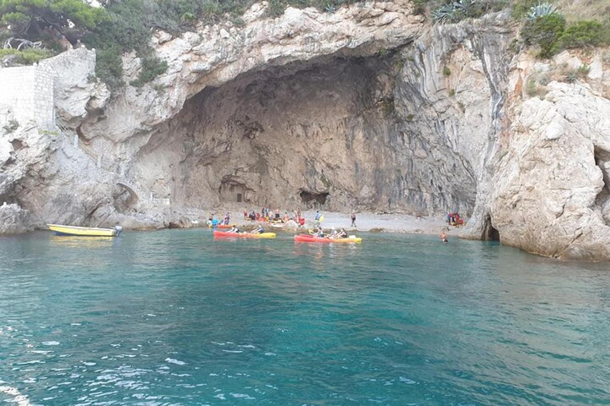 un gruppo di persone in kayak davanti a una grotta