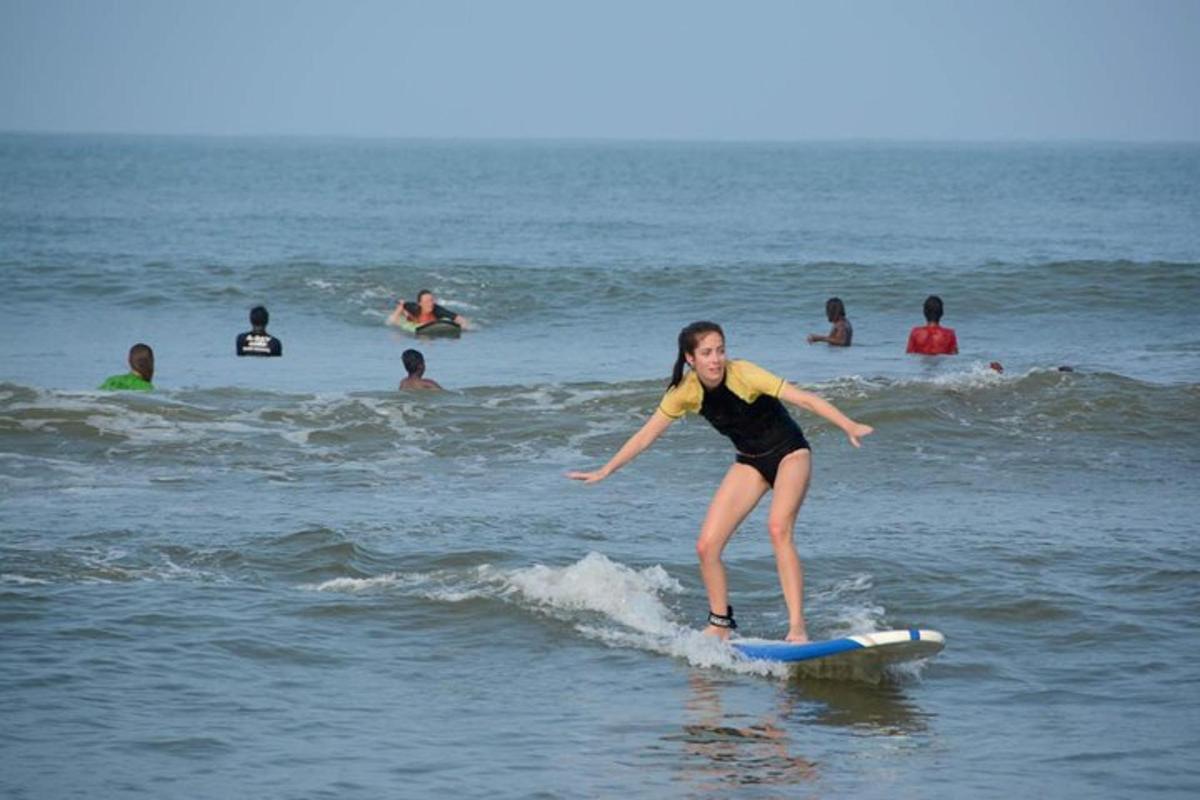 een jong meisje dat op een surfplank in de oceaan op een golf rijdt