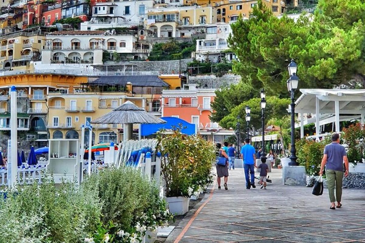 un gruppo di persone che camminano lungo una strada con edifici