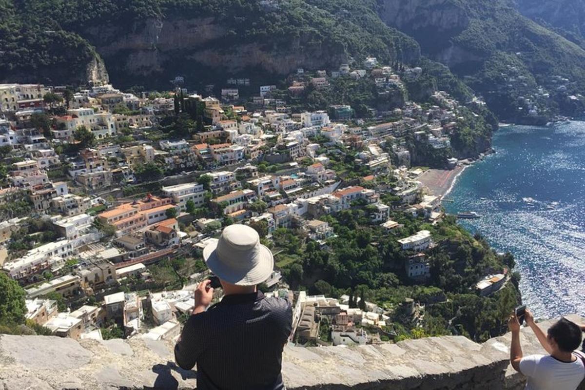 due persone in piedi su una scogliera che guardano una città