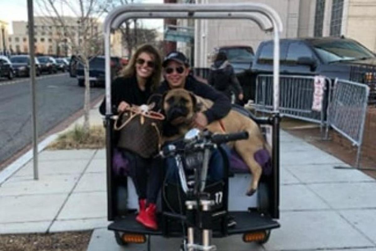 dues dones que van en bicicleta amb un gos a sobre