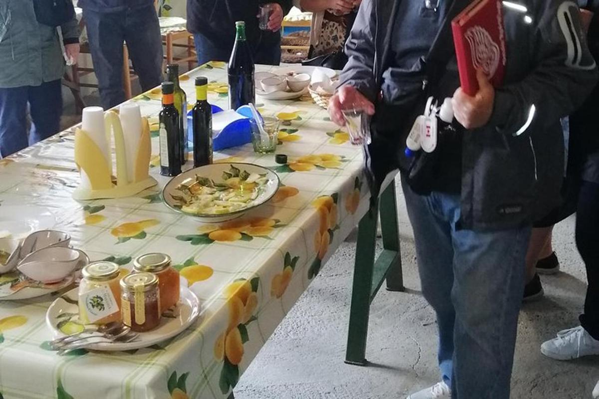 o persoană care stă lângă o masă cu mâncare și vin