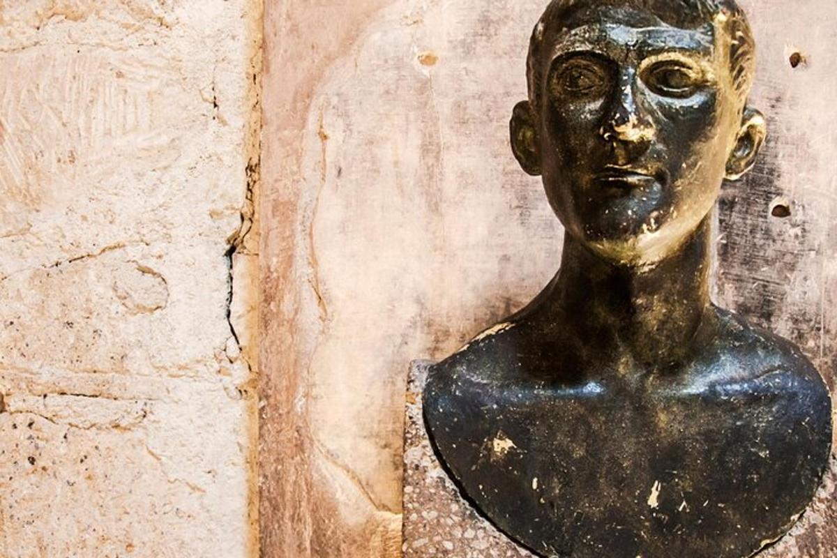 un busto in bronzo di un uomo su un muro