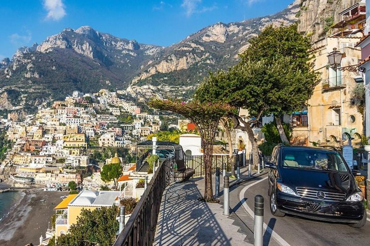 un'auto parcheggiata sul lato di una città con le montagne