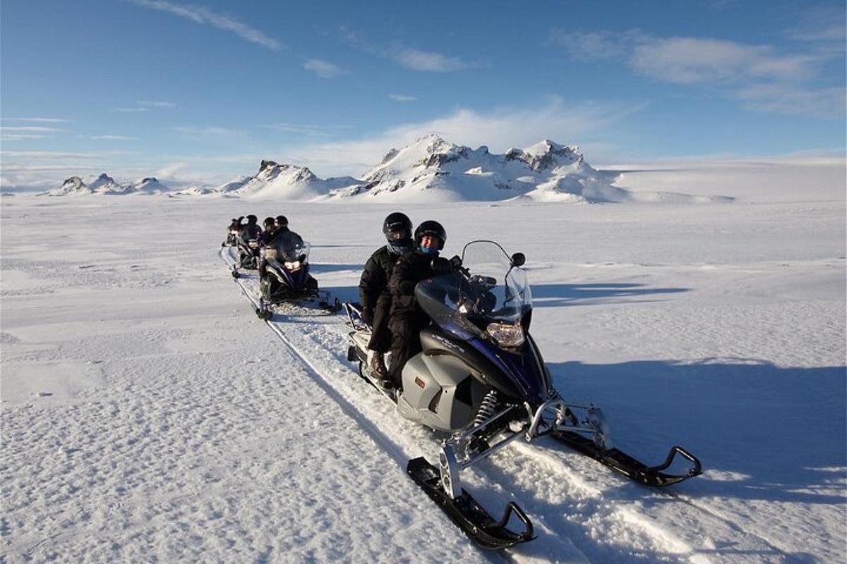 hópur fólks á snjósleða í snjónum