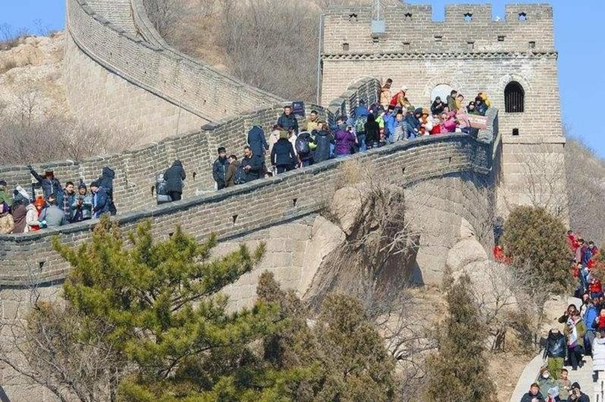 uma multidão de pessoas caminhando sobre um muro