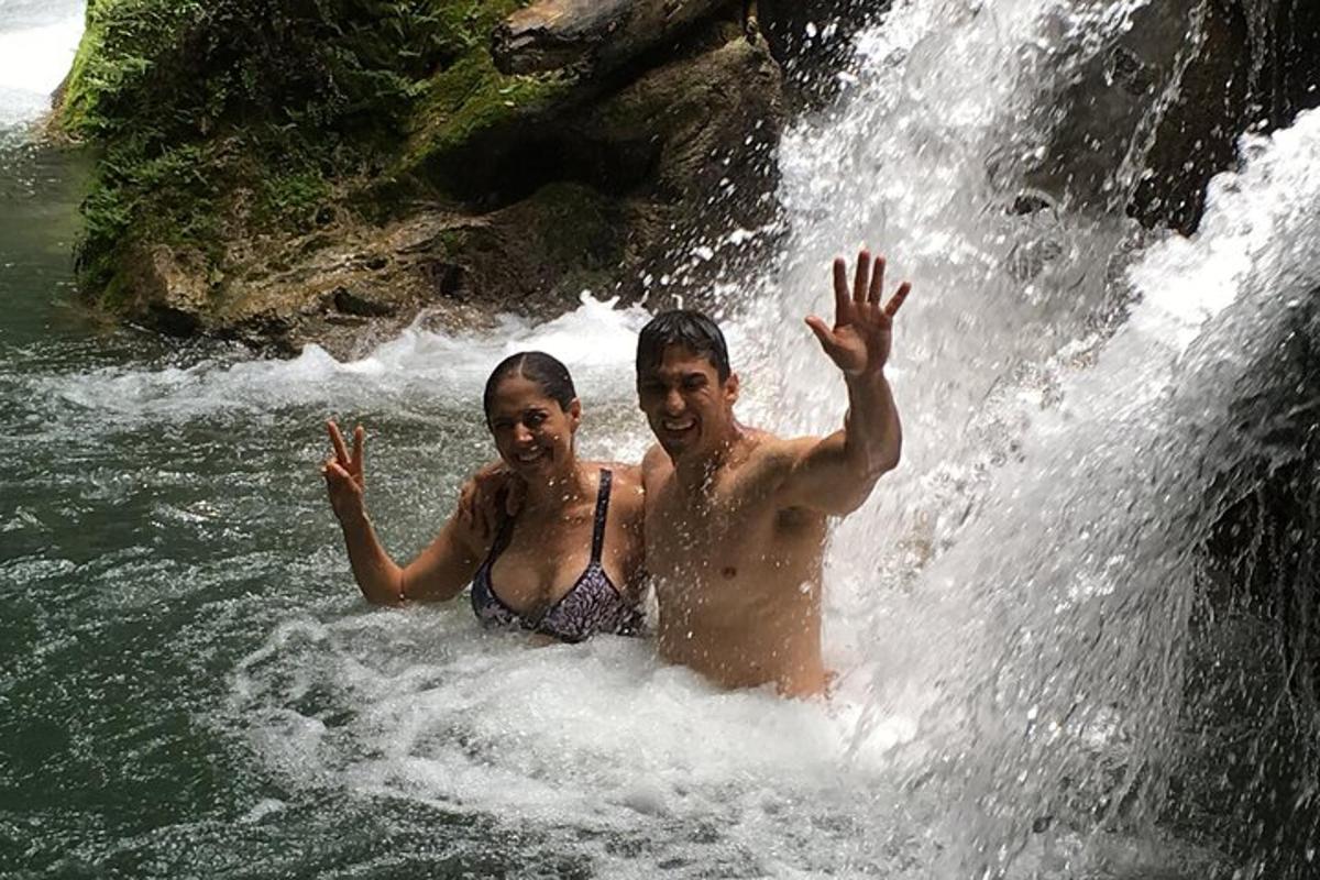 dalawang lalaking nakatayo sa tubig sa isang talon