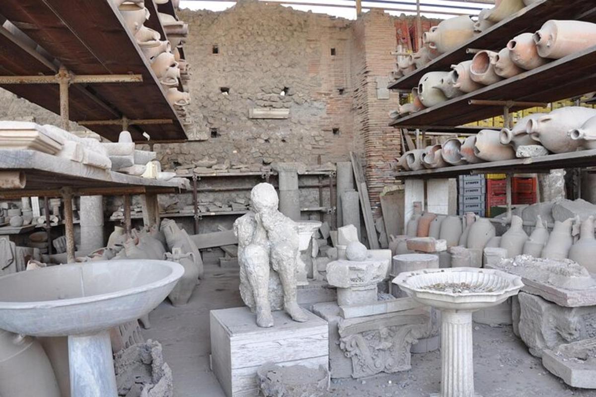 o sculptură a unui bărbat într-o cameră plină de ceramică