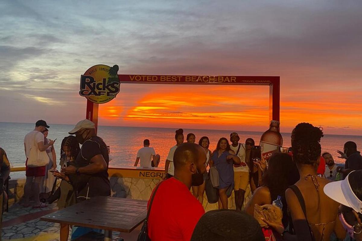 Una multitud de personas mirando la puesta de sol en la playa