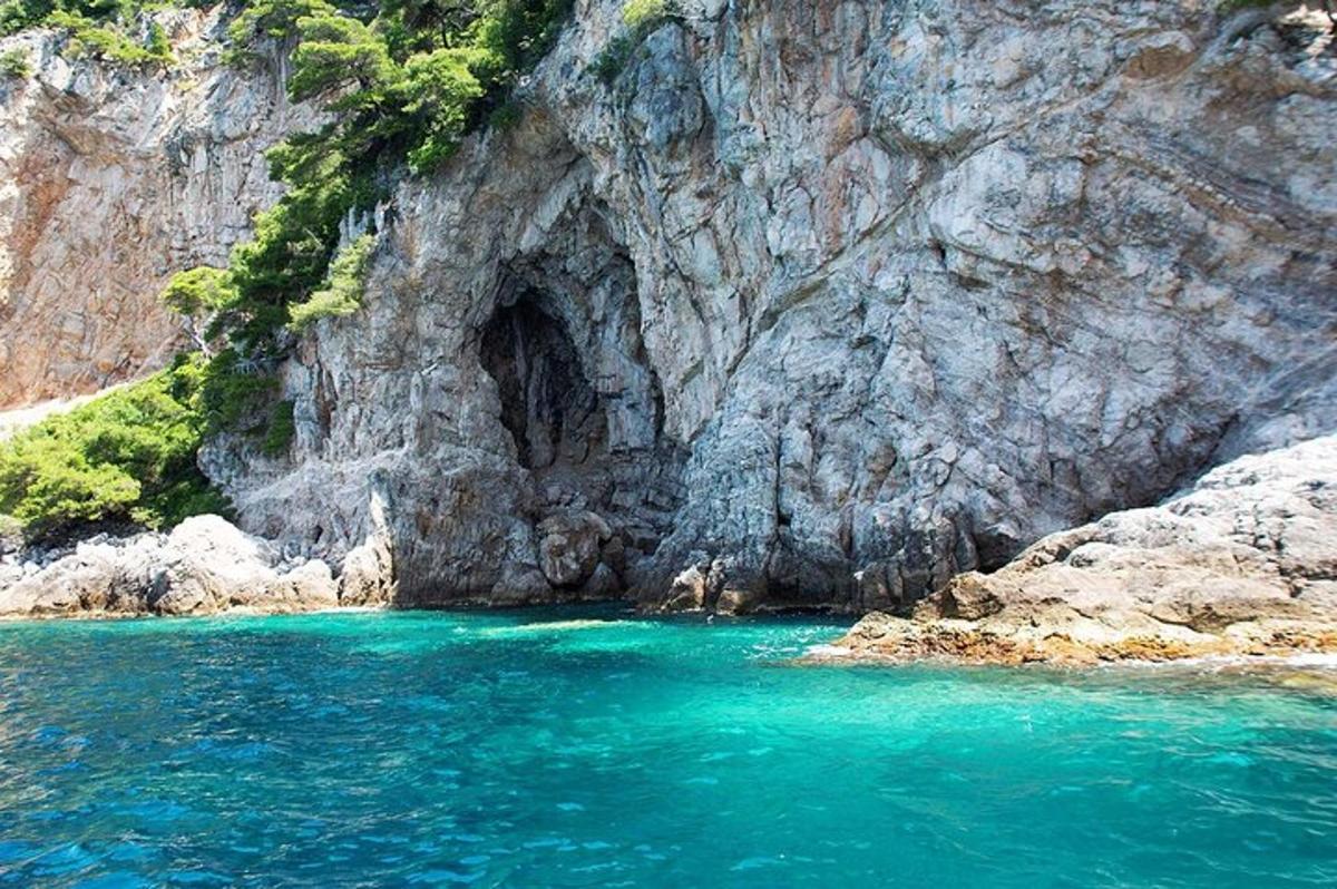 una grotta nel fianco di una montagna con acqua blu