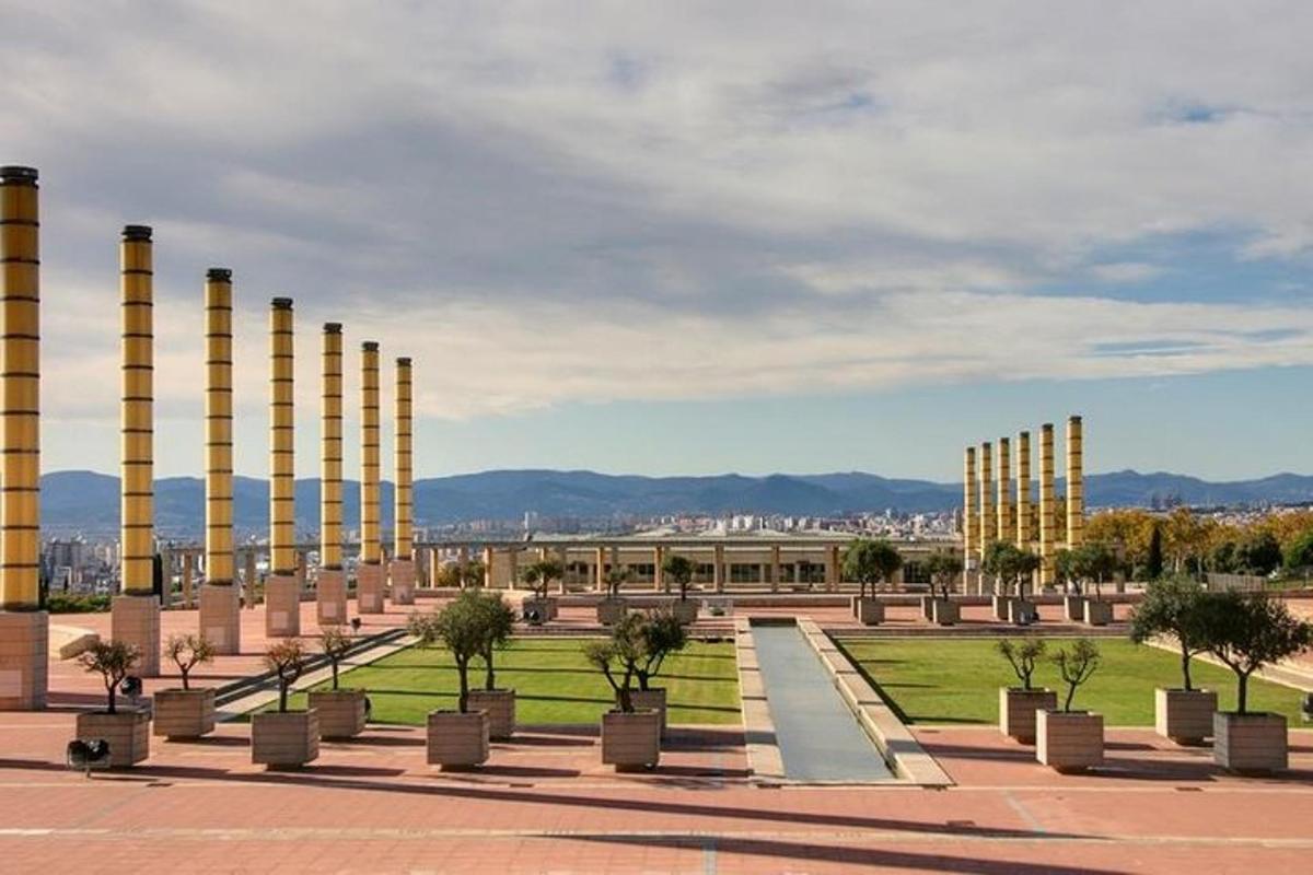 una fila de columnas con árboles en un parque