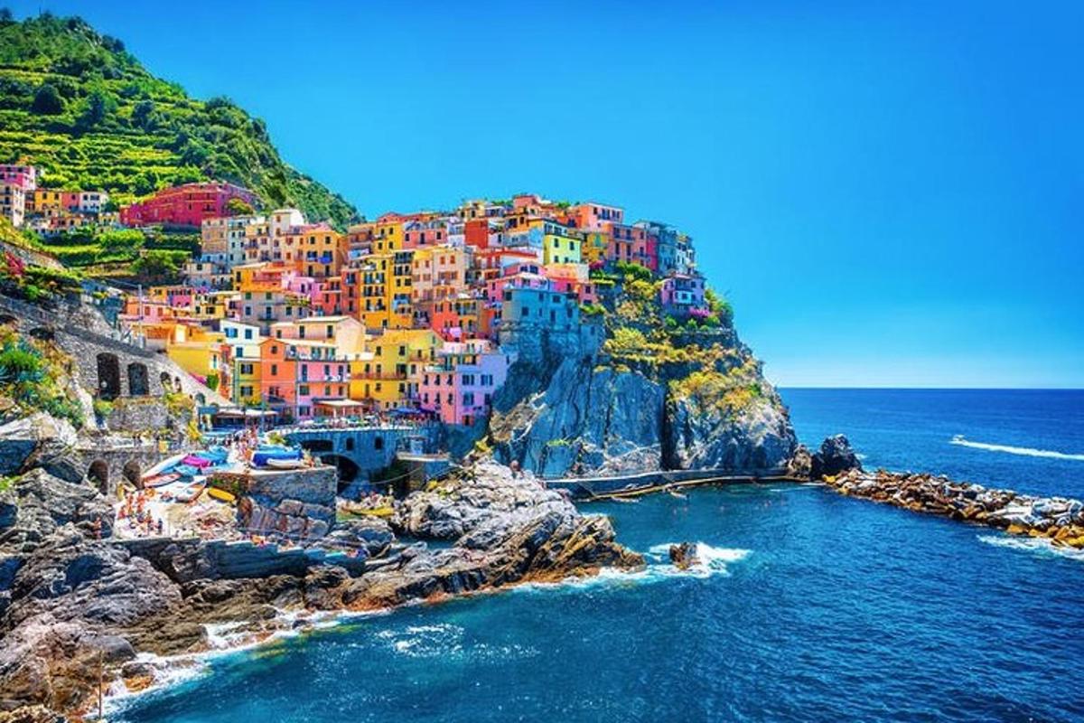 a group of colorful houses on a cliff next to the ocean