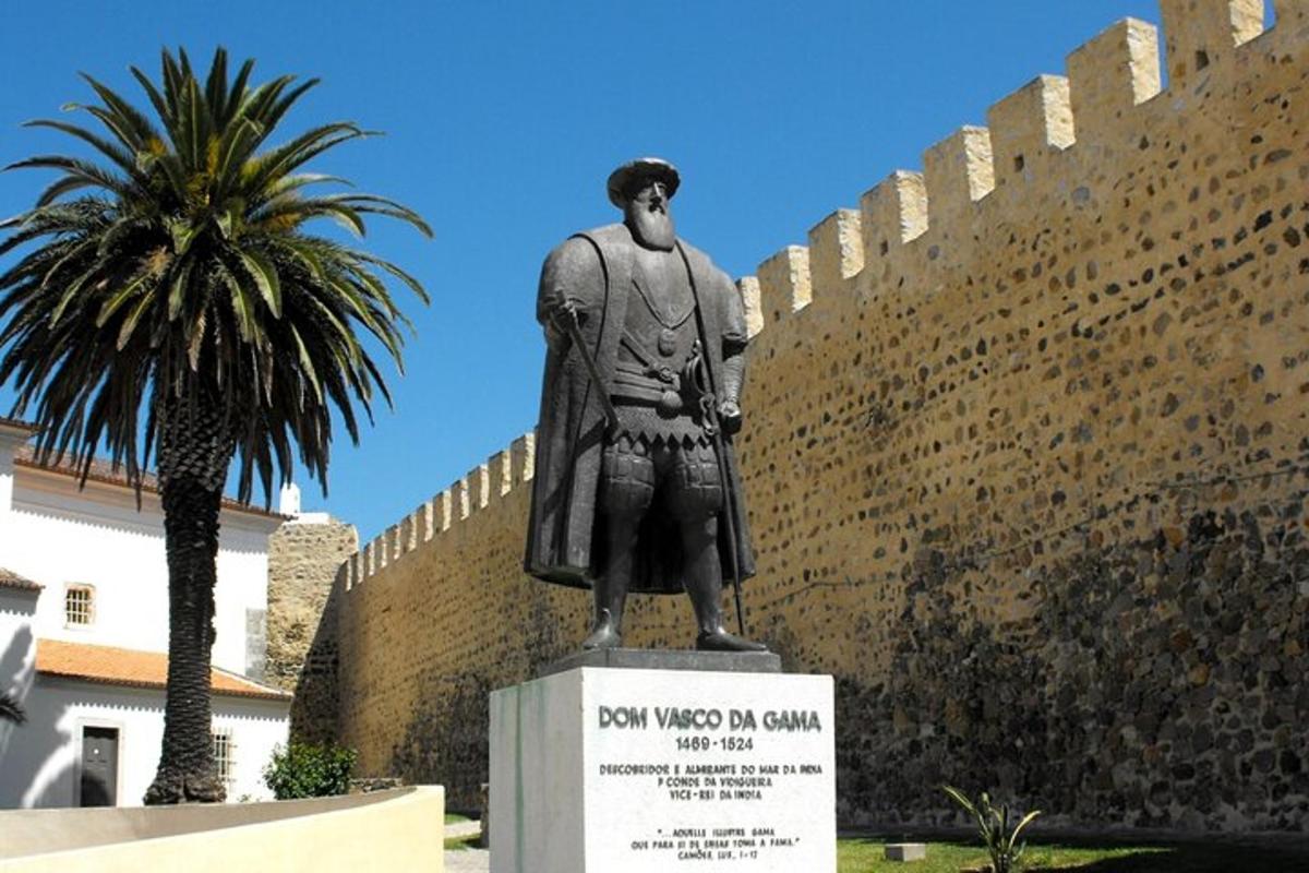 uma estátua de um homem em pé ao lado de uma parede