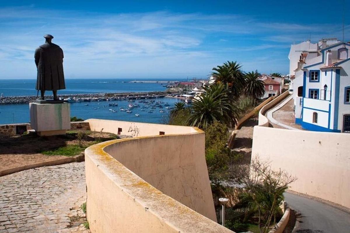 uma estátua de um homem em pé no topo de um muro