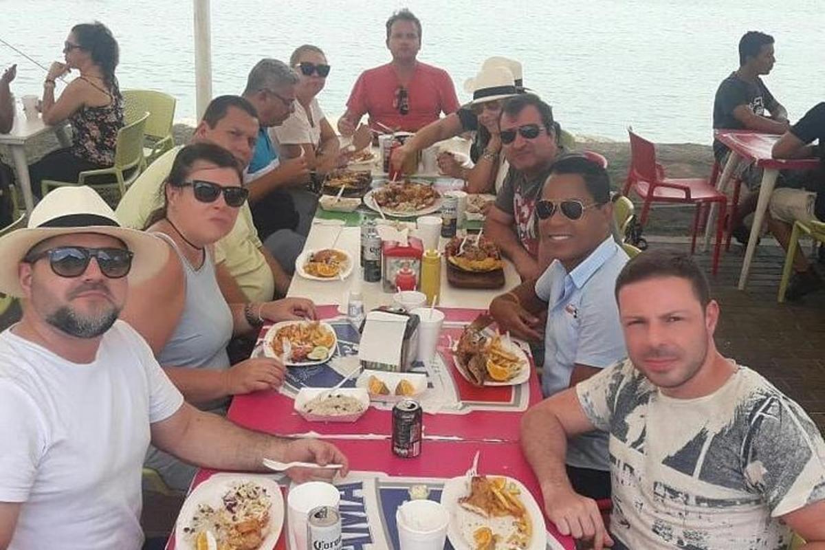 um grupo de pessoas sentadas à mesa comendo comida