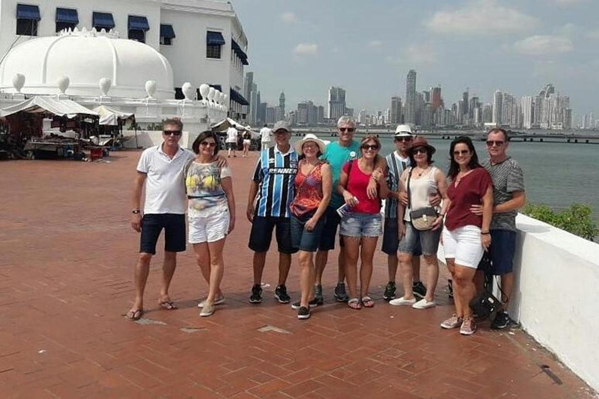 um grupo de pessoas posando para uma foto perto da água