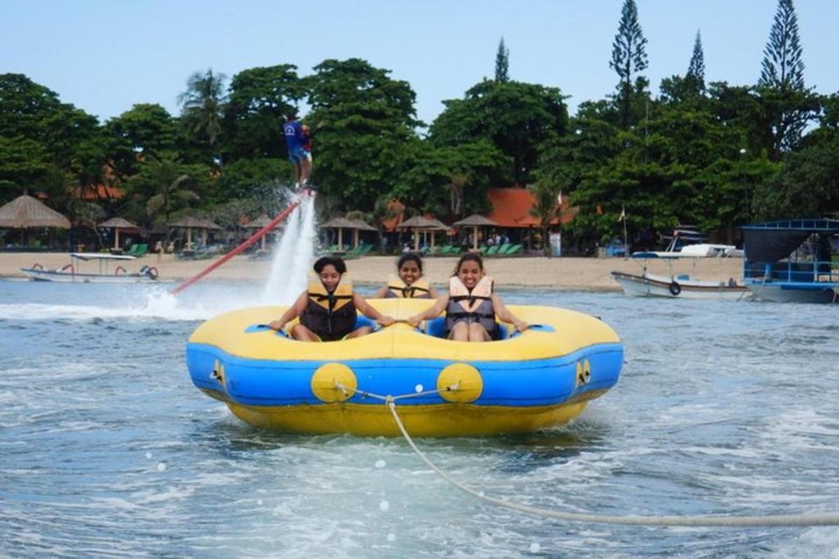 Tres chicas en traje de baño montando en una balsa en el agua