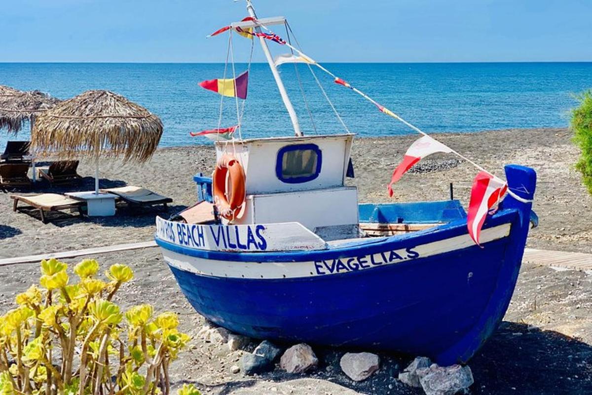 Blár bátur situr á ströndinni við hafið