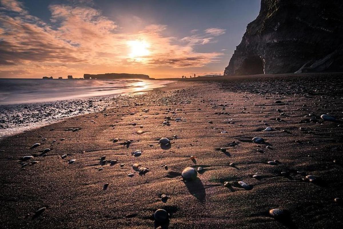 una spiaggia con conchiglie sulla sabbia al tramonto