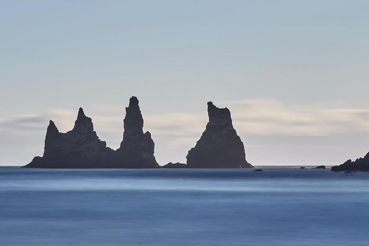 un gruppo di rocce nell'oceano con il cielo