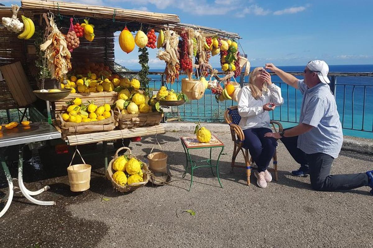 moški in ženska sedita pred stojnico s sadjem