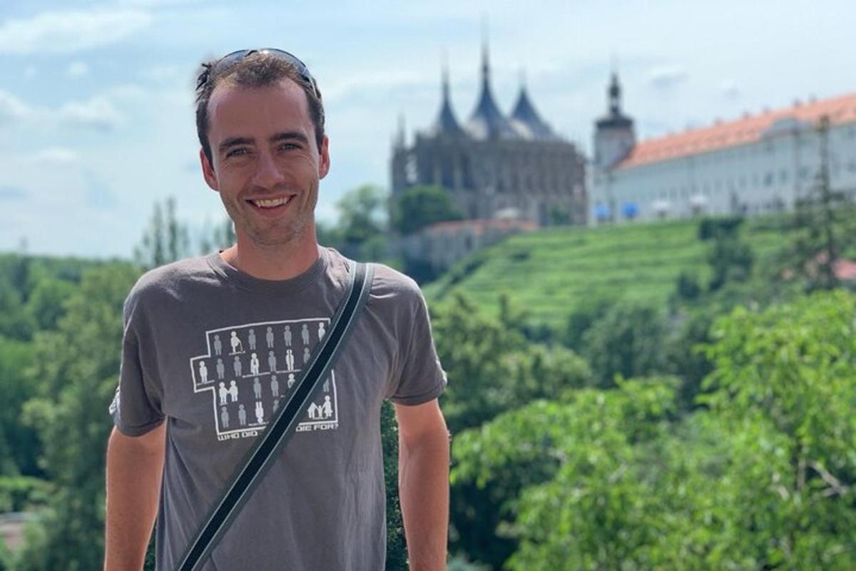 muž stojící před kopcem s hradem
