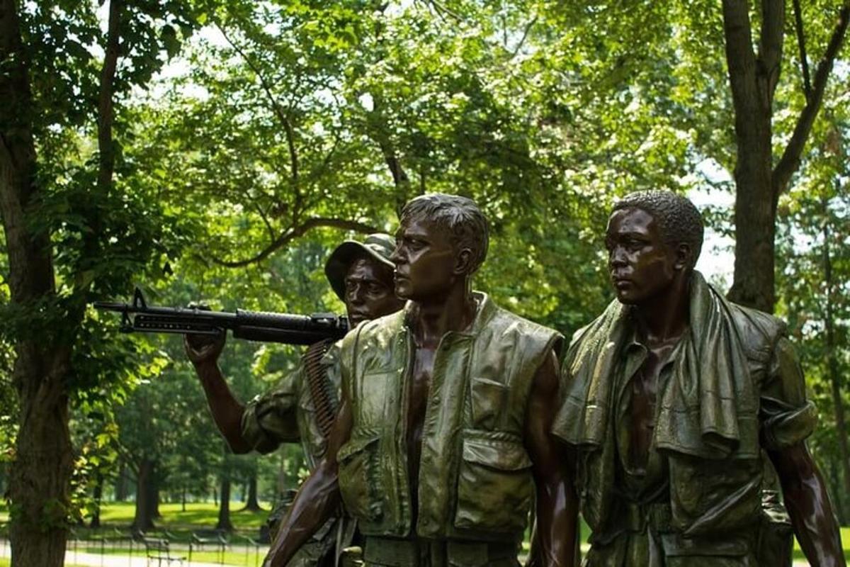 o statuie a trei bărbați cu o armă într-un parc