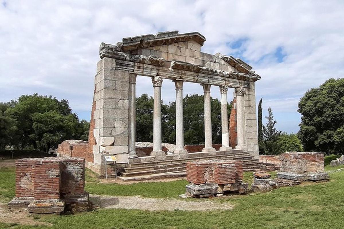 un vecchio edificio in pietra con colonne su un campo
