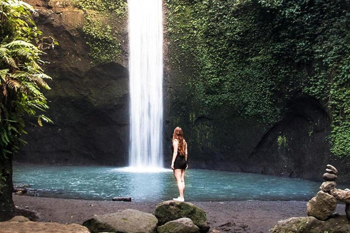 seorang wanita berdiri di depan air terjun