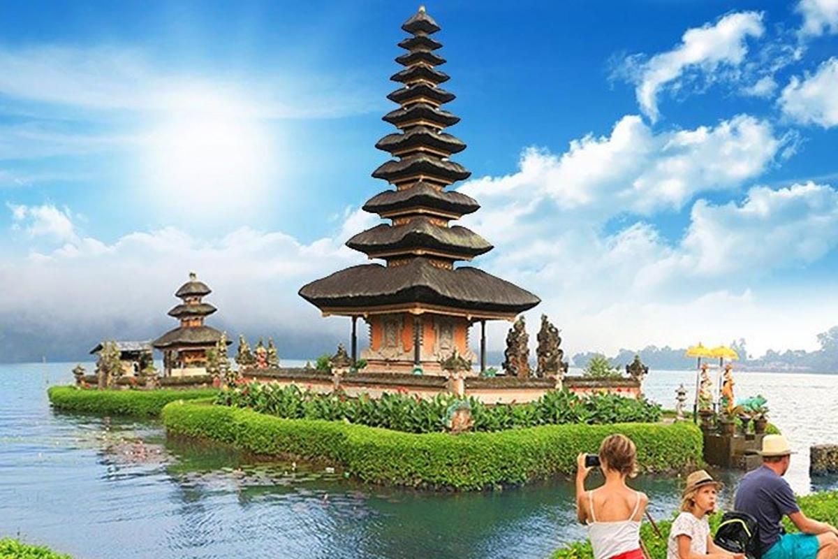 un grup de persones fent fotos d'una pagoda a l'aigua
