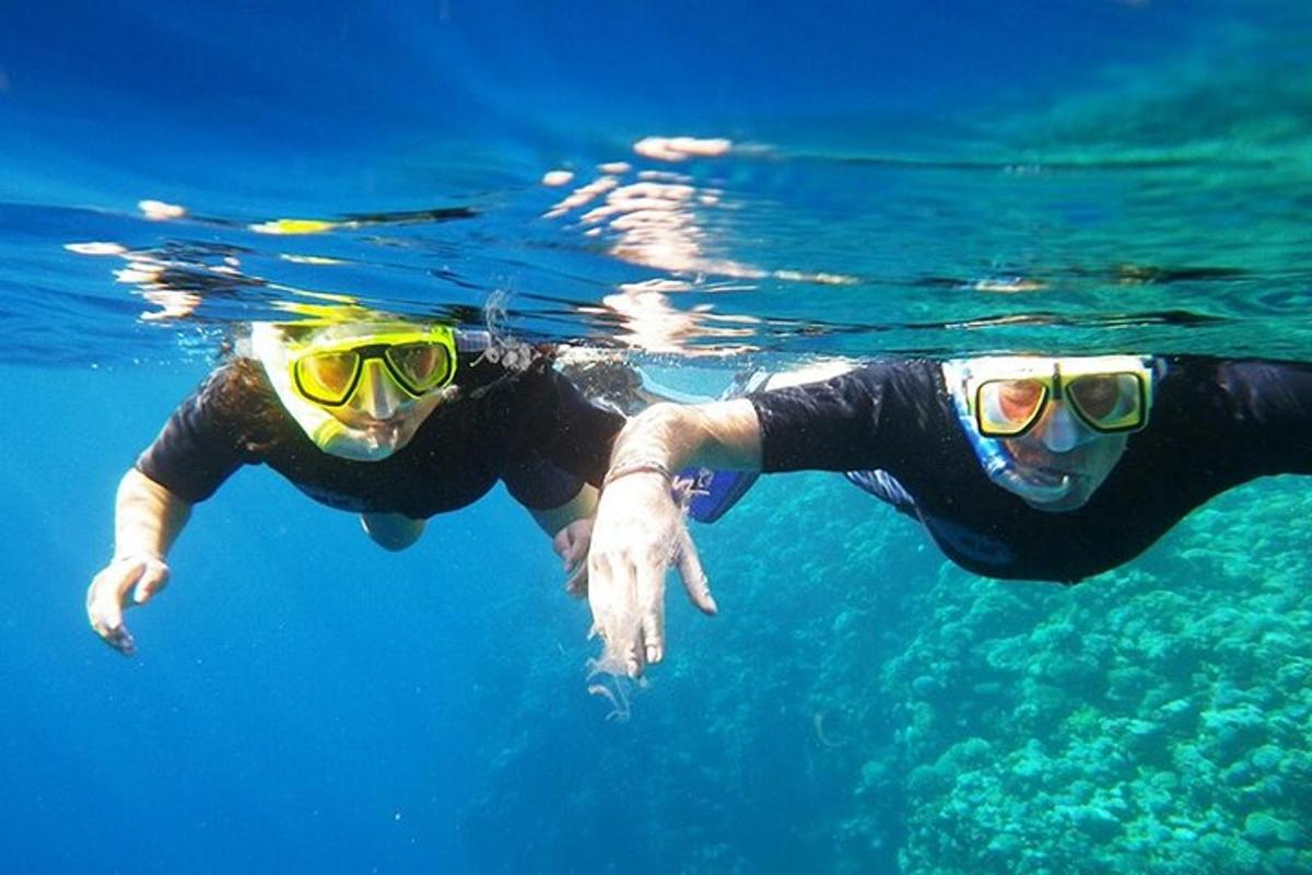zwei Personen mit Schwimmbrillen schwimmen im Wasser