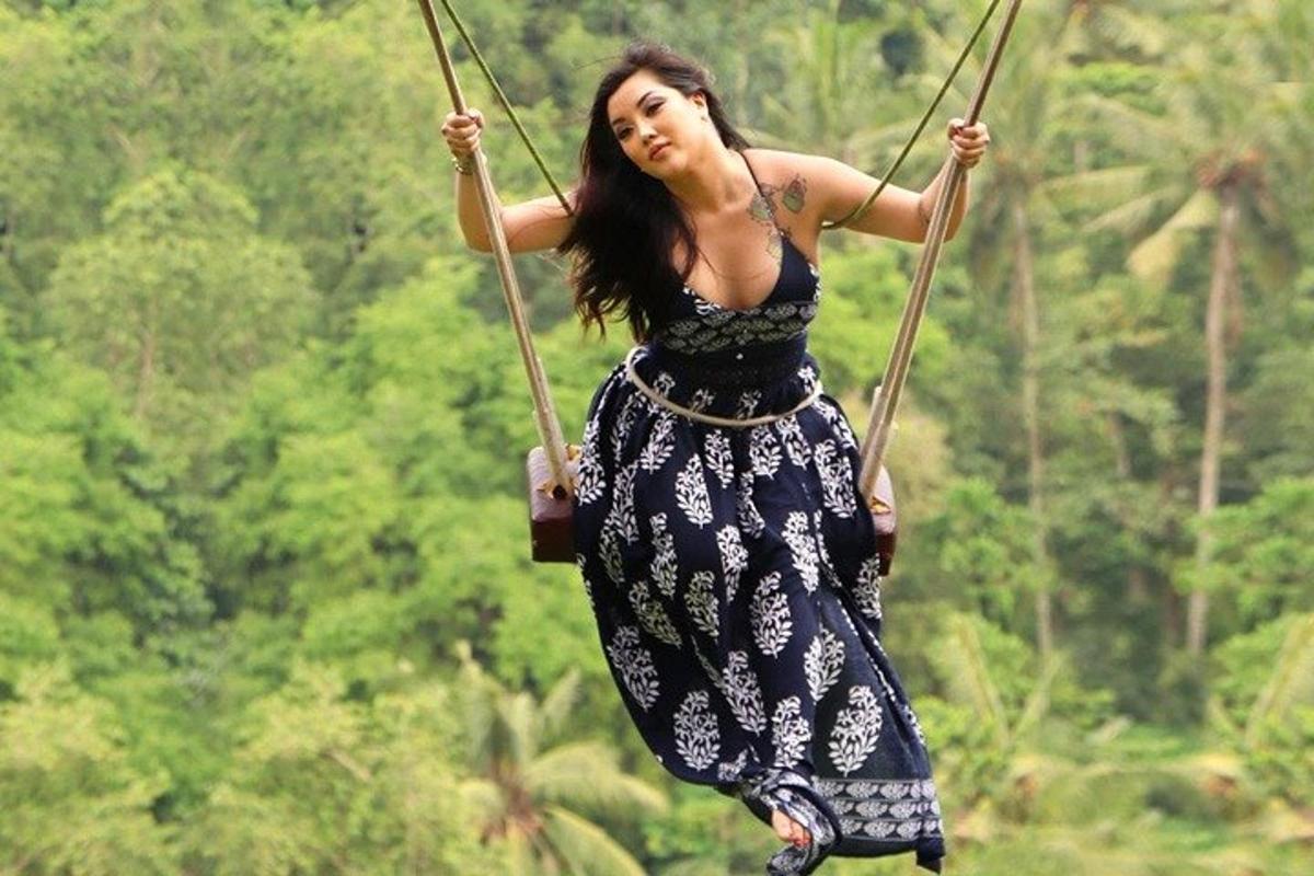 uma mulher de vestido andando em um balanço