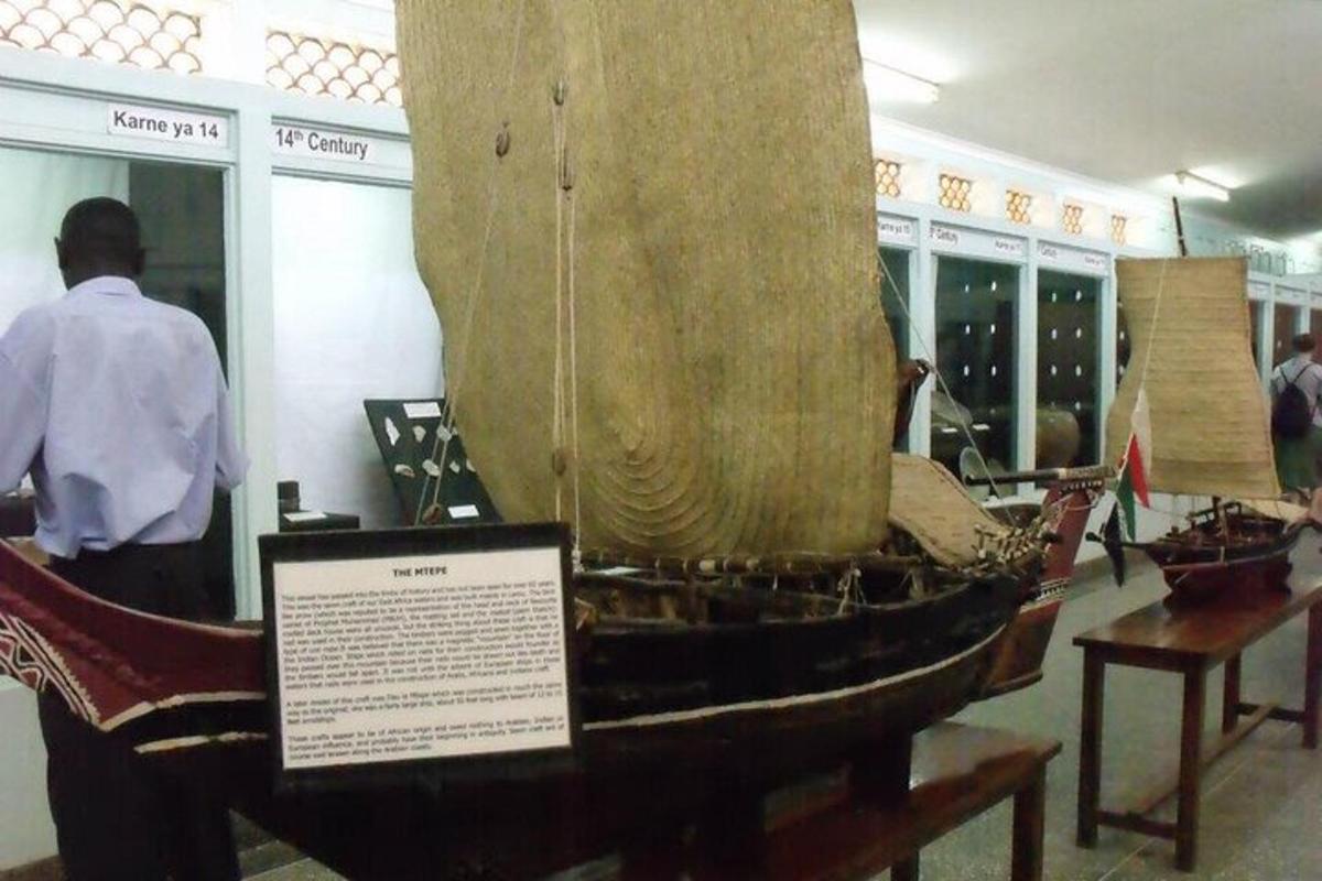 ein Mann steht neben einem Boot in einem Museum